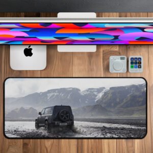 Defender driving through mountain terrain printed on premium desk mat.