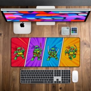 Shell Squad Comic Desk Mat on a wooden desk with monitor, keyboard and mouse